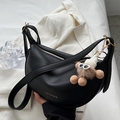 Chic black half-moon saddle bag in pebbled leather with a cute plush charm accessory - With Charm / Black