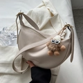 Chic beige half-moon saddle bag in pebbled leather with a cute plush doll charm - With Charm / Off White