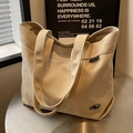 Bolso tote minimalista de lona color blanco roto con etiqueta lateral y correas anchas - Caqui
