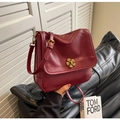 Detalle de bolso vintage de cuero burdeos con un elegante cierre giratorio de flor dorada - Burdeos
