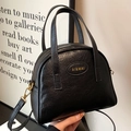 Klassische schwarze halbkreisförmige Muscheltasche mit Narbenstruktur und Goldlogo - Schwarz