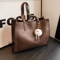 Deep brown leather tote bag with white contrast stitching and plush doll accessory - Coffee