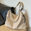 Große beige Oxford-Stoff-Einkaufstasche mit schwarz-weißem Seilgriff auf Steinsockel - Gebrochenes Weiß