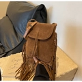 Dettaglio di borsa a secchiello in pelle scamosciata marrone con frange e nodo boho - Cachi
