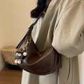 Borsa hobo a mezzaluna marrone scuro in ecopelle con ciondolo di peluche indossata da modella - Nero (Senza Ciondolo)
