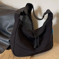 Black nylon crescent crossbody bag with wide strap and minimalist aesthetic detail - Black
