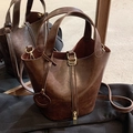 Retro-Beuteltasche aus dunkelbraunem Leder mit Griffen und dekorativem Smiley-Anhänger - Braun