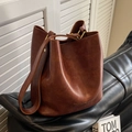Dunkelbraune Vintage-Eimertasche aus strukturiertem Kunstleder mit goldenem Logo - Braun