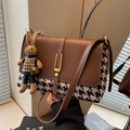 Brown leather tote with houndstooth pattern and cute rabbit pendant shown in hand - Brown Houndstooth With Pendant