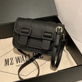 Minimalist black pebble leather satchel with gold hardware and flap buckle design - Black
