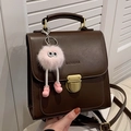 Dunkelbraune Handtasche aus Kunstleder mit Riemen und rosa Plüsch-Monster-Anhänger - Kaffeebraun (Mit Anhänger)
