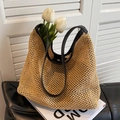 Beige woven straw bucket bag with black leather handles and hollow knit design - Black