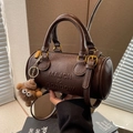 Bolso Boston de cuero marrón oscuro con asas, bandolera y colgante de oso pequeño - café