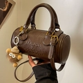 Bolso cilíndrico Boston marrón con letras en relieve y accesorio de peluche colgante - Marrón