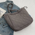 Dark grey quilted canvas tote bag with rhombus pattern and metal buckle on denim jacket - Gray