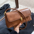 Retro brown leather baguette shoulder bag featuring a sleek gold metal buckle and strap - Brown