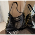 Nahaufnahme der schwarzen Retro-Tragetasche aus Kunstleder mit M-Logo und Goldkette - Schwarz
