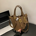 Dunkelbraune Beuteltasche aus Leder mit Lychee-Struktur, Golddekor und Elefantenanhänger - Hellkaffee