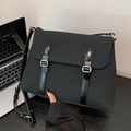 Minimalistische schwarze Nylon-Umhängetasche mit goldenen Schnallen auf dem Tisch - Schwarz