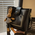 Black bucket bag with ethnic woven strap and cute knit rabbit charm accessory - Black