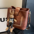 Vintage brown bucket bag with a knitted rabbit charm and patterned wide strap - Brown