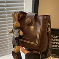 Dark brown PU leather bucket bag with colorful woven strap and cute bunny pendant - Coffee