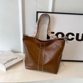 Borsa a secchiello in pelle marrone con borchie argento e tracolla larga a spina di pesce - Marrone