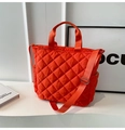 Detail of orange quilted nylon tote bag showing diamond stitching and adjustable strap - Orange
