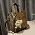 Brown quilted bucket bag with adjustable shoulder strap and cute plush charm - With Charm / Argyle Brown
