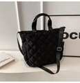 Detail of black quilted tote bag showing rhombus stitching and adjustable nylon shoulder strap - Black