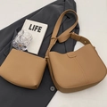 Brown lychee leather bucket bag and pouch set on a blazer with lifestyle props - Khaki