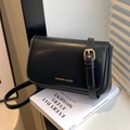 Classic black vintage crossbody bag with gold lettering on a minimalist studio set - Black