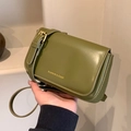Mini avocado green matte leather crossbody bag with gold lettering held by hand - Green