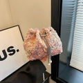 Pink holographic sequin bucket bag with pearl drawstring details held in hand - Pink