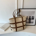 Borsa tote in paglia beige con finiture in ecopelle marrone e borchie in un ambiente minimalista - Bianco Sporco