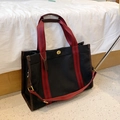Large black canvas tote bag with red-black striped straps and gold metal turn-lock - Large / Black