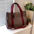 Brown canvas tote bag with striped handles and gold twist lock in sunlight - Large / Brown