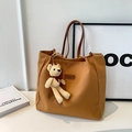 Braune Canvas-Tragetasche mit Lederriemen und beigem Teddybär-Anhänger aus Strick - Braun mit Anhänger