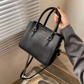 Elegant black lychee textured handbag with gold hardware and adjustable strap - Black