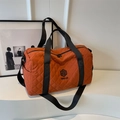 Quilted orange travel duffel bag with black handles and adjustable shoulder strap - Orange