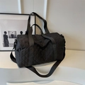 Black quilted travel bag with diamond patterns and adjustable shoulder strap - Black