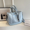 Light blue high capacity nylon tote bag with shoulder strap in minimalist studio setting - Blue with Pendant