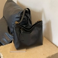Large black leather dumpling bag with golden metal buckle and decorative tag - Black