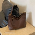 Vintage brown leather dumpling tote bag with sleek gold hardware and brand tag - Brown