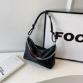 Schicke schwarze Schultertasche mit dunkler Textur und bernsteinfarbener Perlenkette - Schwarz