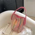 Pink woven tote bag with colorful vertical stripes and leather straps on white chair - Pink