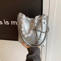 Silberne Falten-Tasche mit Gliederkette und Marmorperlen-Griff in der Hand - Silber