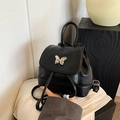 Mini black leather backpack featuring a silver butterfly buckle and drawstring closure - Black