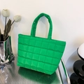 Vibrant emerald green quilted tote bag with padded handles on a silver metal chair - Green
