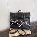 Sac à dos plissé noir chic pour femme avec nœuds roses et plaque de logo métallique - Noir